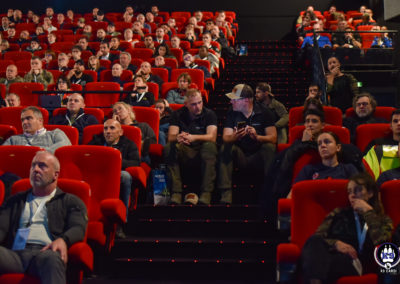 Audience assise dans la salle de conférence, avec les deux fondateurs du salon Cyno-Ops