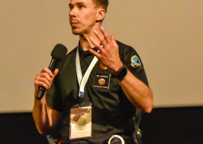 Intervenant sur scène pendant une conférence sur Cyno-Ops